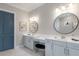Elegant bathroom with dual sinks, vanity area, round mirrors, and modern lighting at 5510 Panella Ct, Palmetto, FL 34221