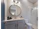 Bright bathroom with a single sink, round mirror, and a glass-enclosed shower for a clean aesthetic at 5510 Panella Ct, Palmetto, FL 34221