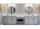 Elegant bathroom with dual sinks, vanity area, round mirrors, and modern lighting at 5510 Panella Ct, Palmetto, FL 34221