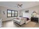 Bright bedroom featuring neutral tones, a ceiling fan, plantation shutters, and a comfortable sofa at 5510 Panella Ct, Palmetto, FL 34221