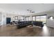 Open concept living room with a large sofa, hardwood floors, and sliding glass doors to the backyard at 5510 Panella Ct, Palmetto, FL 34221