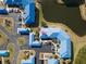 Aerial view of community homes with blue roofs, surrounded by parking, landscaping, and a pond at 835 Audubon Dr # 835, Bradenton, FL 34209