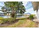 Landscaped backyard with a serene pond view, lush greenery, and well-maintained lawn space at 835 Audubon Dr # 835, Bradenton, FL 34209