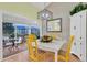 Bright dining area with white table, yellow chairs, and access to a screened balcony at 835 Audubon Dr # 835, Bradenton, FL 34209