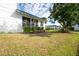 Exterior view of a white home with a blue roof, green grass, and nearby shrubbery under a cloudy sky at 835 Audubon Dr # 835, Bradenton, FL 34209