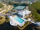 Aerial view of a community pool, tennis court, and clubhouse surrounded by lush landscaping and waterways at 835 Audubon Dr # 835, Bradenton, FL 34209