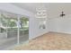 Open living room with tile flooring, a modern ceiling fan and a large sliding door to the patio at 4337 Mermell Cir, North Port, FL 34291