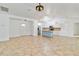 Spacious living room with a tile floor, a kitchen, and a white front door at 4337 Mermell Cir, North Port, FL 34291