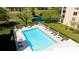 Inviting community swimming pool surrounded by lounge chairs and umbrellas for relaxation at 4480 Fairways Blvd # 109, Bradenton, FL 34209