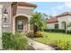 Home's exterior features an arched entryway and manicured landscaping at 212 Casalino Dr, Nokomis, FL 34275