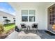 Cozy front porch with two wicker chairs and small table at 1119 Waterline Ct, Sarasota, FL 34240