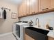 Laundry room with farmhouse sink, modern washer and dryer at 1119 Waterline Ct, Sarasota, FL 34240