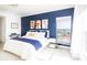 Spacious bedroom with a large window, plush bedding, and a navy blue accent wall at 808 3Rd W Ave # 701, Bradenton, FL 34205