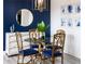 Elegant dining room with glass-top table, gold chairs, and a blue accent wall at 808 3Rd W Ave # 701, Bradenton, FL 34205