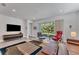 Open living space featuring hardwood floors, a large TV, and access to a patio at 2563 Prospect St, Sarasota, FL 34239