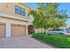 Two-car garage and well-maintained landscaping in front of tan townhome at 4157 Overture Cir # 383, Bradenton, FL 34209