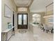 Grand foyer with decorative tile flooring, elegant lighting, and a view into the dining area at 8019 Royal Birkdale Cir, Lakewood Ranch, FL 34202