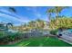 Tropical backyard oasis with a lush lawn, palm trees, and a patio at 5309 Hidden Harbor Rd, Sarasota, FL 34242