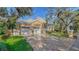 House exterior featuring a two-car garage, manicured lawn, and a brick driveway at 5309 Hidden Harbor Rd, Sarasota, FL 34242