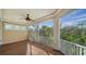 Spacious screened porch with wood decking, ceiling fan, and tranquil wooded views at 5309 Hidden Harbor Rd, Sarasota, FL 34242