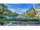 Serene waterfront view from a stone patio, lush landscaping, and canal view at 5309 Hidden Harbor Rd, Sarasota, FL 34242