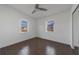 Bright bedroom with dark wood-look tile floors and two windows at 258 Seminole Nw Blvd, Port Charlotte, FL 33952