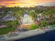 An aerial view of a waterfront home with palm trees and a sunset at 1358 Moonmist Dr # B4, Sarasota, FL 34242