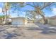 View of the home's garage and paved driveway with mature landscaping at 1358 Moonmist Dr # B4, Sarasota, FL 34242