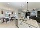 Eat-in kitchen features an island, granite countertops, and white cabinetry at 14118 Florida Rosemary Dr, Bradenton, FL 34211