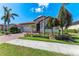 Front elevation featuring a brick driveway, a two-car garage and lush landscaping at 123 Pescador Pl, Nokomis, FL 34275