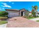 Charming home featuring a lush green lawn and a brick driveway at 123 Pescador Pl, Nokomis, FL 34275