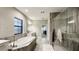 A luxurious bathroom featuring a soaking tub and a large glass-enclosed shower at 12661 Oak Hill Way, Parrish, FL 34219