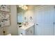 Well-lit half-bath with a decorative mirror, framed art, and a white vanity with storage at 12661 Oak Hill Way, Parrish, FL 34219