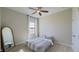 Simple bedroom with a comfortable bed, a full-length mirror, and a window dressed with floral curtains at 12661 Oak Hill Way, Parrish, FL 34219
