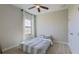 Neutral-toned bedroom featuring a comfortable bed, a window dressed with floral curtains, and a ceiling fan at 12661 Oak Hill Way, Parrish, FL 34219