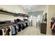 Walk-in closet features custom wood shelving, drawers, full length mirror, and neutral-toned carpet at 12661 Oak Hill Way, Parrish, FL 34219