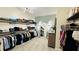 Walk-in closet features custom wood shelving, full length mirror, modern lighting, and carpet flooring at 12661 Oak Hill Way, Parrish, FL 34219