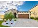 Charming one-story home featuring a brick paver driveway and a well-manicured yard with palm tree at 12661 Oak Hill Way, Parrish, FL 34219