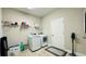 Laundry room boasts a newer washer and dryer, shelving, and modern vinyl plank flooring at 12661 Oak Hill Way, Parrish, FL 34219