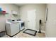 Laundry room boasts a newer washer and dryer, tile floors, and modern vinyl plank flooring at 12661 Oak Hill Way, Parrish, FL 34219