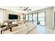 Bright living room with tile floors, large sectional, and sliding glass doors to the outdoor patio area at 12661 Oak Hill Way, Parrish, FL 34219