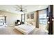 Spacious main bedroom featuring a bed, a ceiling fan, and large windows with curtains at 12661 Oak Hill Way, Parrish, FL 34219