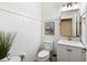 Modern powder room with white shiplap and a sleek gold mirror at 13107 Belknap Pl, Lakewood Ranch, FL 34211