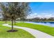 Peaceful walkway alongside a lake with lush landscaping at 13107 Belknap Pl, Lakewood Ranch, FL 34211