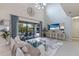 Spacious living room with high ceilings, large TV, and comfy sofas at 13107 Belknap Pl, Lakewood Ranch, FL 34211
