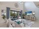 Spacious living room with high ceilings, large TV, and comfy sofas at 13107 Belknap Pl, Lakewood Ranch, FL 34211