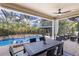 Covered patio with dining table and pool view at 13107 Belknap Pl, Lakewood Ranch, FL 34211