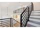 Modern staircase with metal railing and view of kitchen and living room at 2318 Bay St, Sarasota, FL 34237