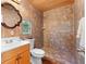 Rustic bathroom with wood cabinets and tile shower at 1841 Buccaneer Dr, Sarasota, FL 34231