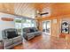 Relaxing living room with gray leather seating, wood ceiling, and access to backyard at 1841 Buccaneer Dr, Sarasota, FL 34231